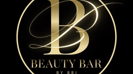 Elegant gold logo of Beauty Bar by Bri, Bridgetown, Saint James, BB, on a black background.