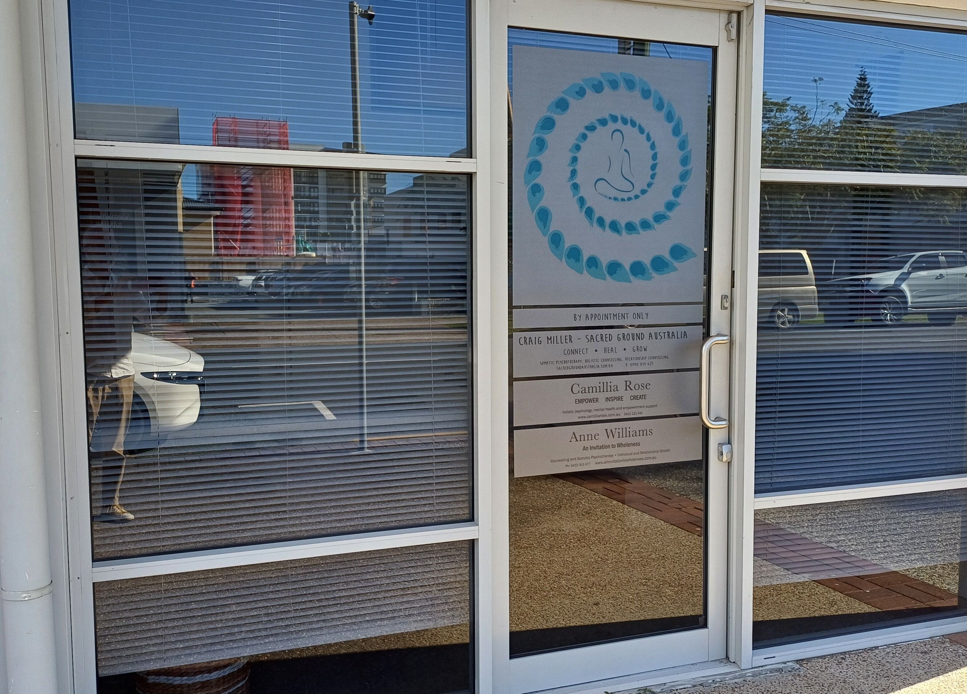 Front entrance of Sacred Ground Australia, Palm Beach, Queensland, AU with logo on door.