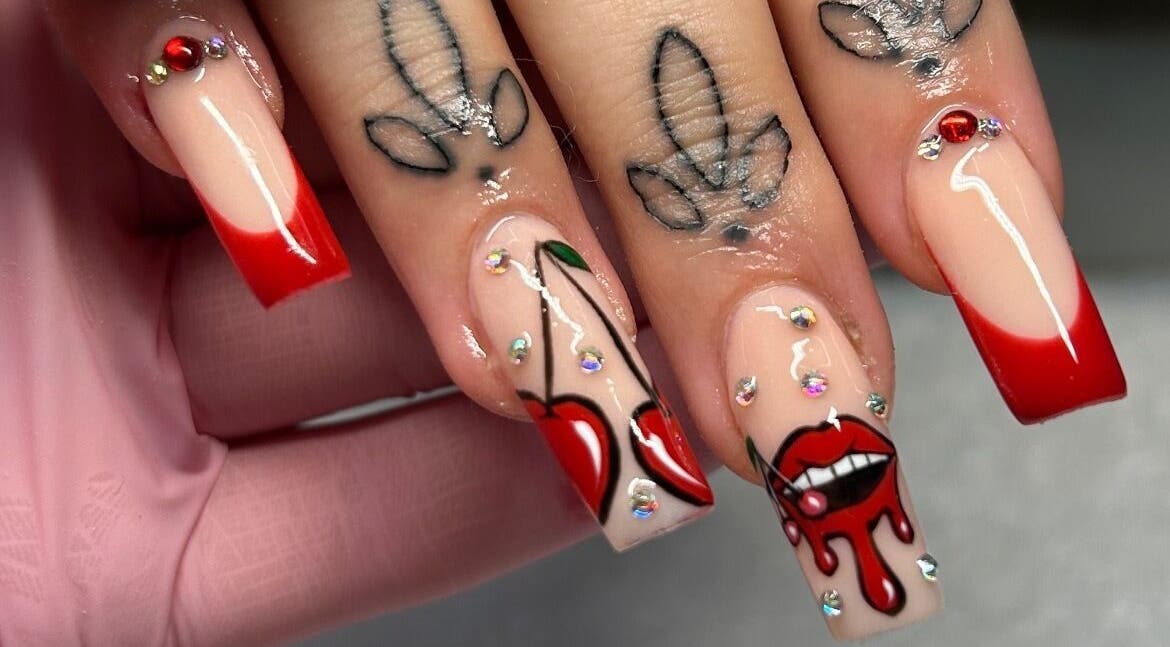 Bold cherry-themed nail art with red tips at The Beaut-E Club, Glasgow, Scotland, GB.