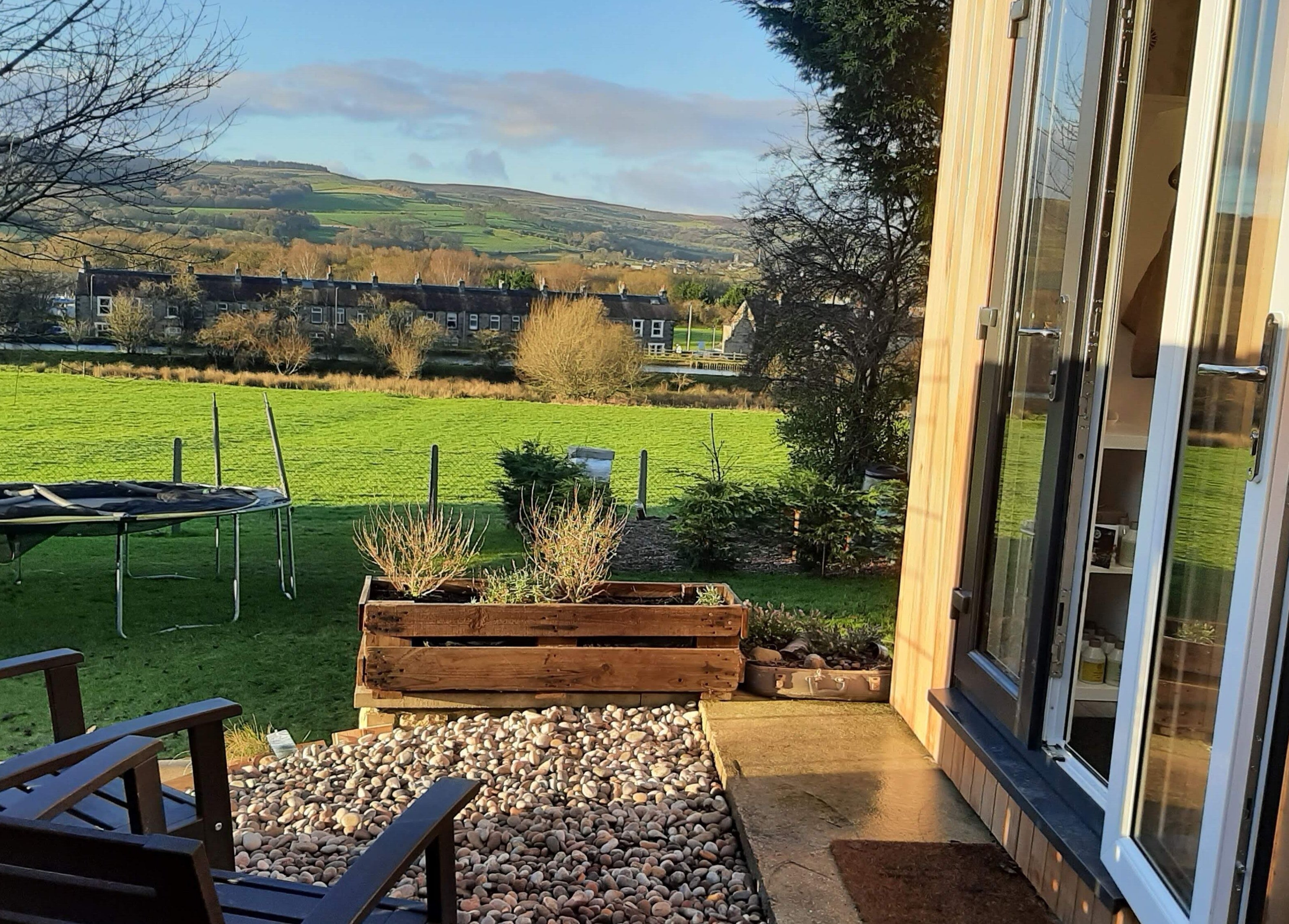 Tranquil garden view from Dawn Waterhouse Salon, Skipton, England, GB with lush greenery and open sky.