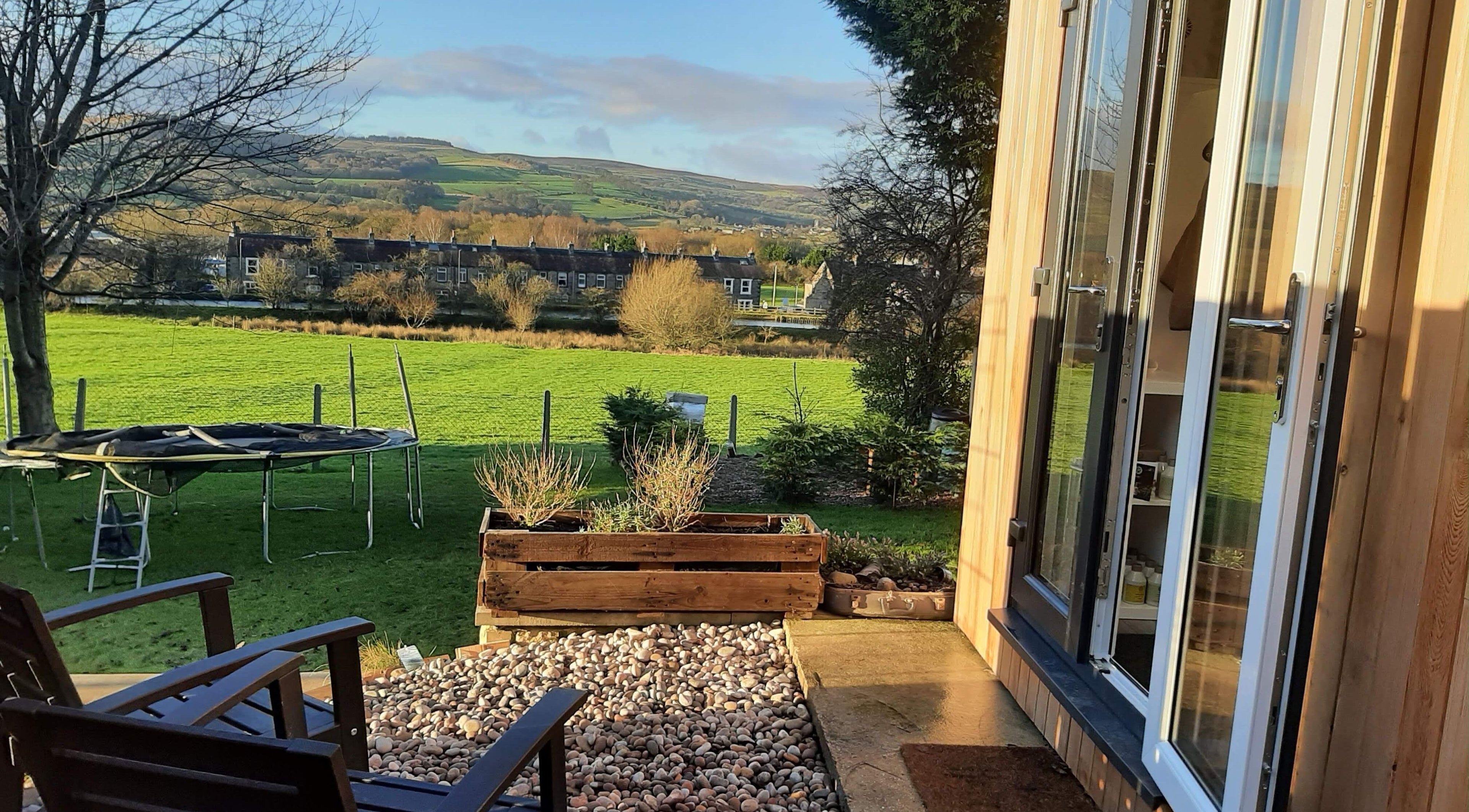 Tranquil garden view from Dawn Waterhouse Salon, Skipton, England, GB with lush greenery and open sky.