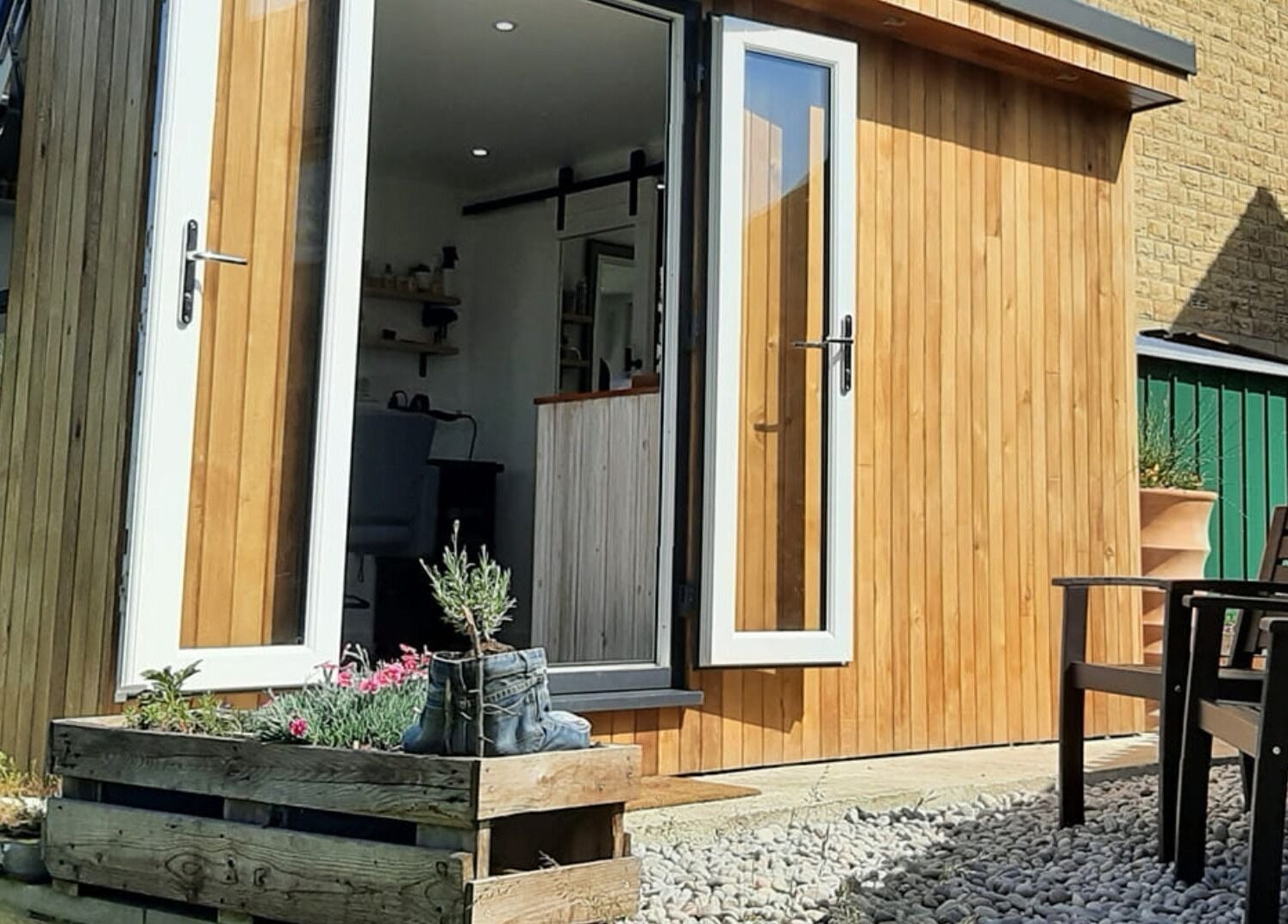 Outdoor view of Dawn Waterhouse Salon in Skipton, England with wooden exterior and garden chairs.