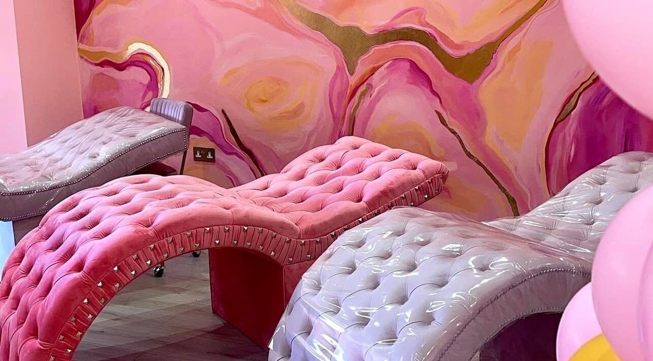 Luxurious pink and gray velvet lounges at The Lash Bolt, Sunderland, England, GB, amid vibrant wall art.