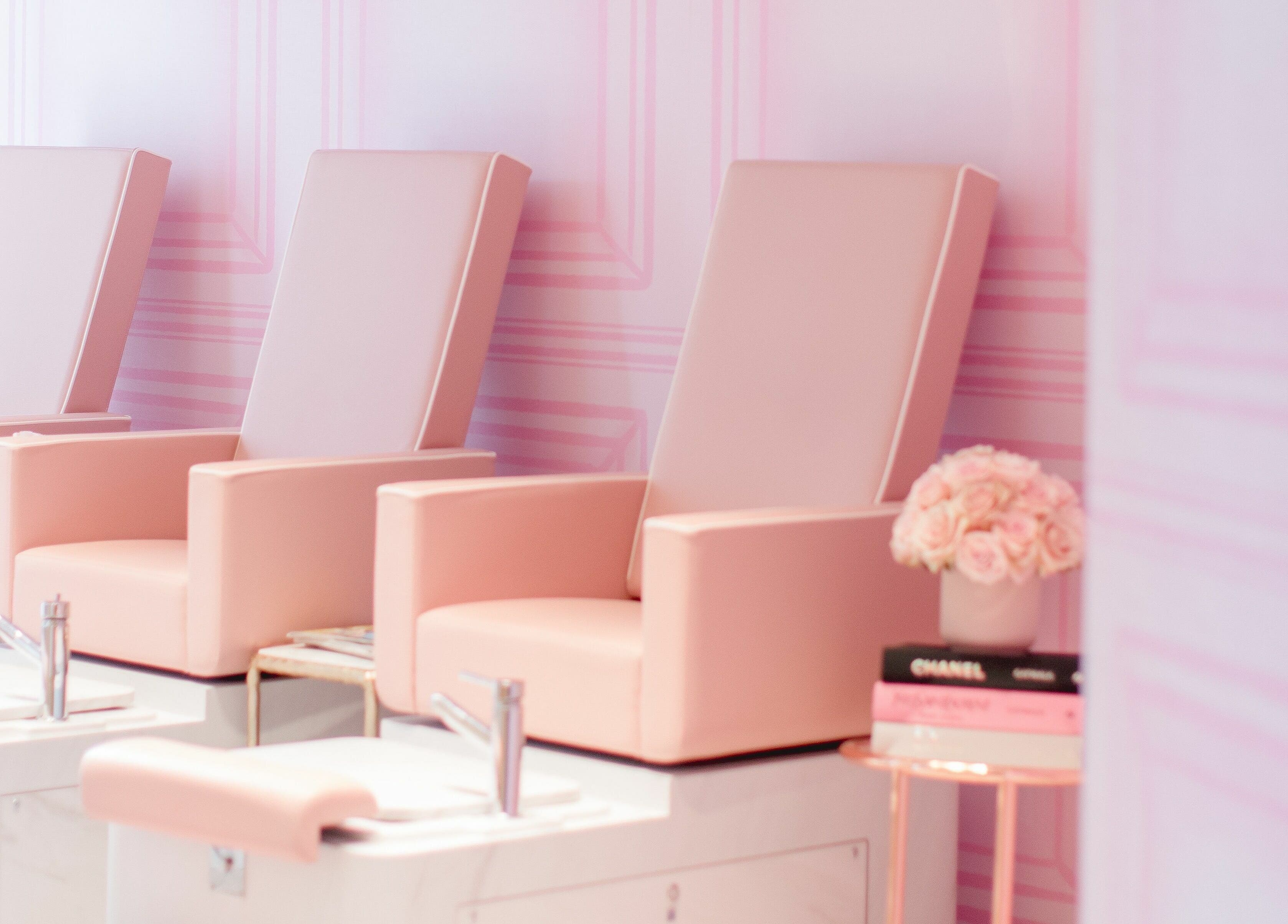 Elegant manicure chairs at Nail'd It Knightsbridge, London, England, GB, in soft pink ambiance.