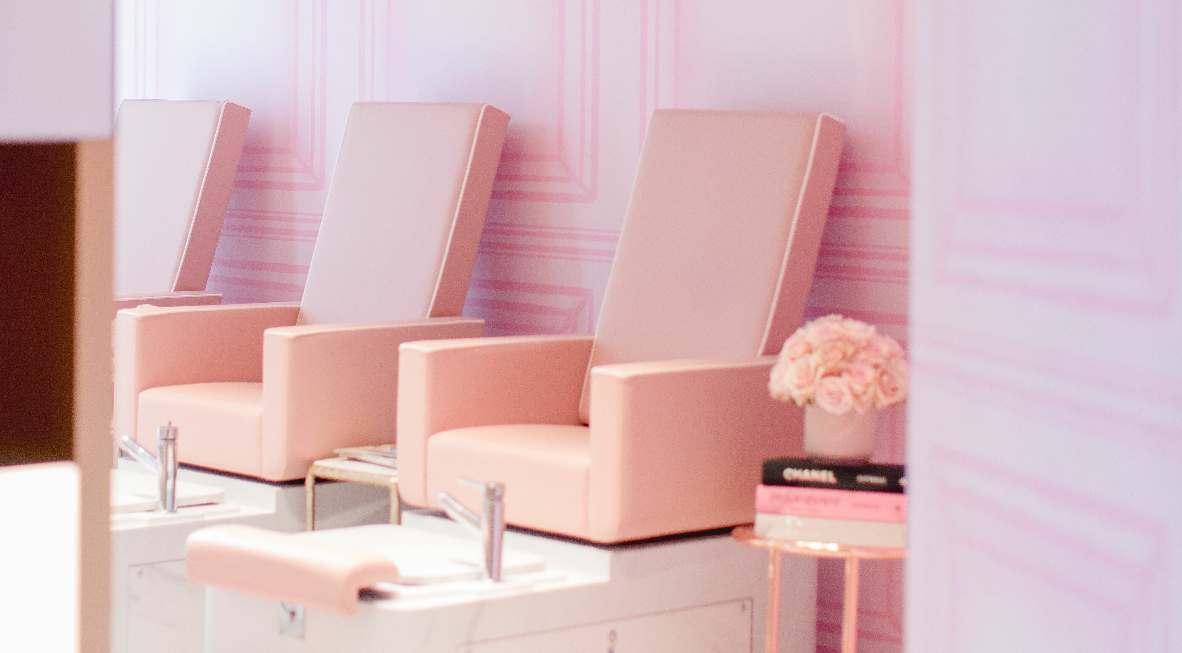 Elegant manicure chairs at Nail'd It Knightsbridge, London, England, GB, in soft pink ambiance.