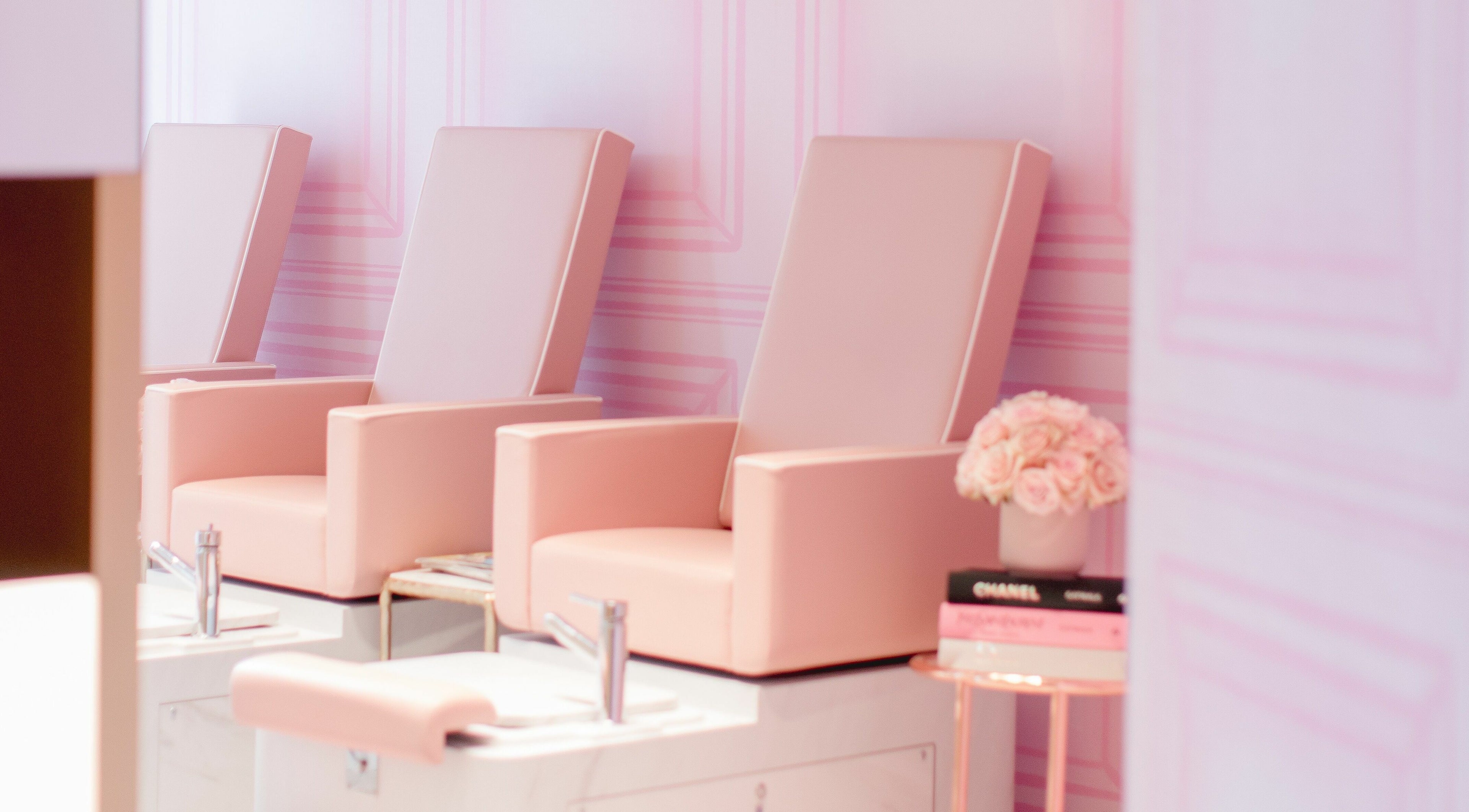 Elegant manicure chairs at Nail'd It Knightsbridge, London, England, GB, in soft pink ambiance.