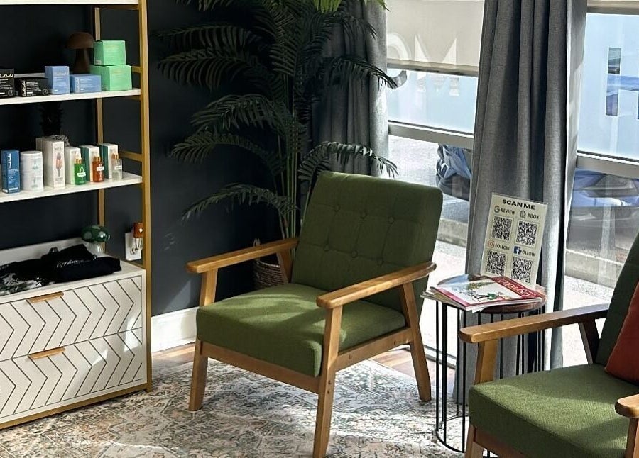 Cozy seating area with green chairs at Mad Wax in Largo, Florida, US featuring a stylish product shelf.