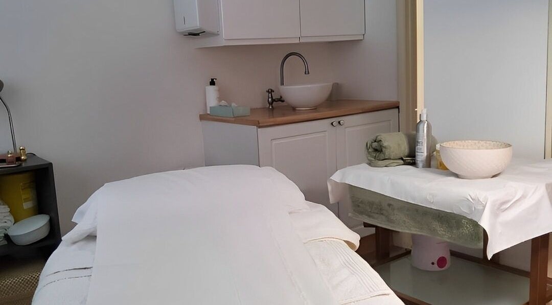 Relaxing treatment room at The Skin Care Clinic, Norwich, England, GB with massage table and sink area.