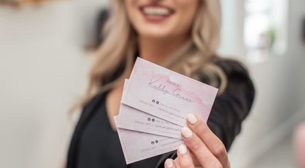 Client holding HairbyKellyGrace business cards in Gqeberha, Eastern Cape, ZA for stylish hair services.
