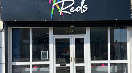 Front entrance of Reds in Hull, England, GB, showcasing elegant glass doors and signage.