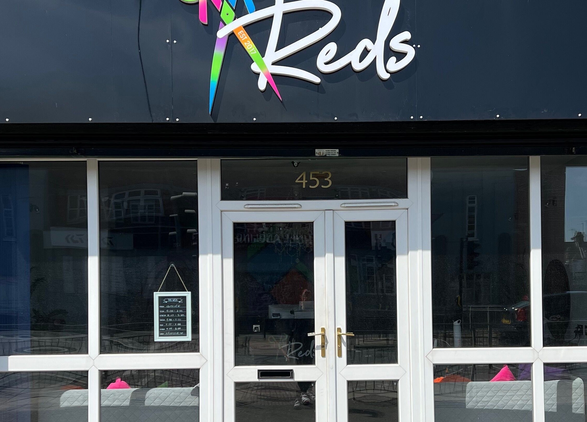 Front view of Reds beauty and wellness salon at 453 Hull, England, GB, showcasing its modern glass facade.