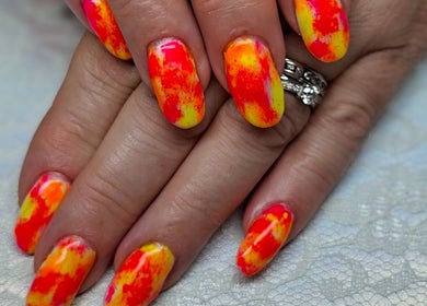 Vibrant multicolor nail art at Pampered Beauties, Sheffield, England, GB showcasing intricate hand design.