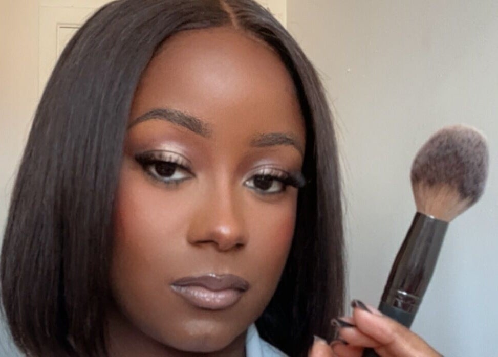 Femme tenant un pinceau de maquillage à The Alexe Glow, Montréal, Québec, CA.