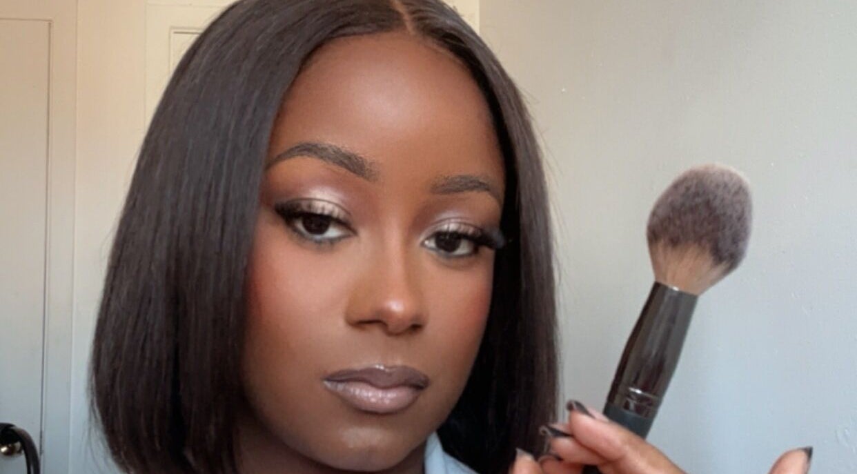 Femme tenant un pinceau de maquillage à The Alexe Glow, Montréal, Québec, CA.