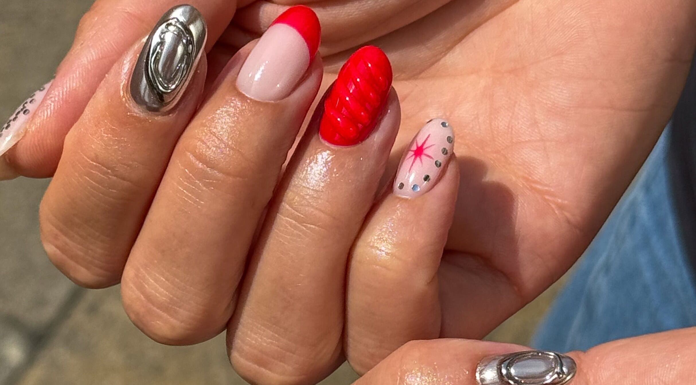 Elegant nail art with red designs at Studio Saku, Manchester, England, GB.