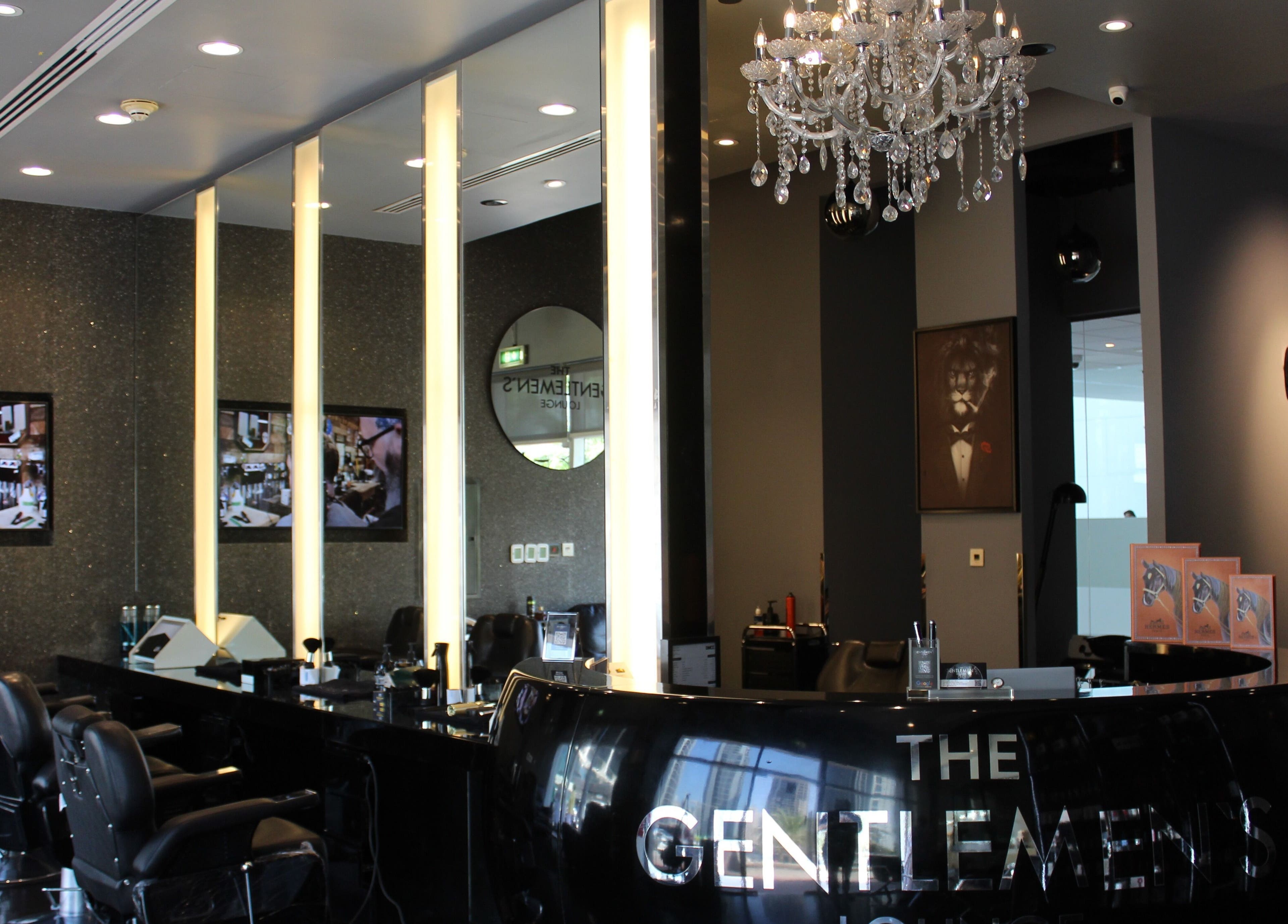 Luxurious interior of The Gentlemen's Lounge in Dubai, AE, showcasing elegant decor and barber chairs.