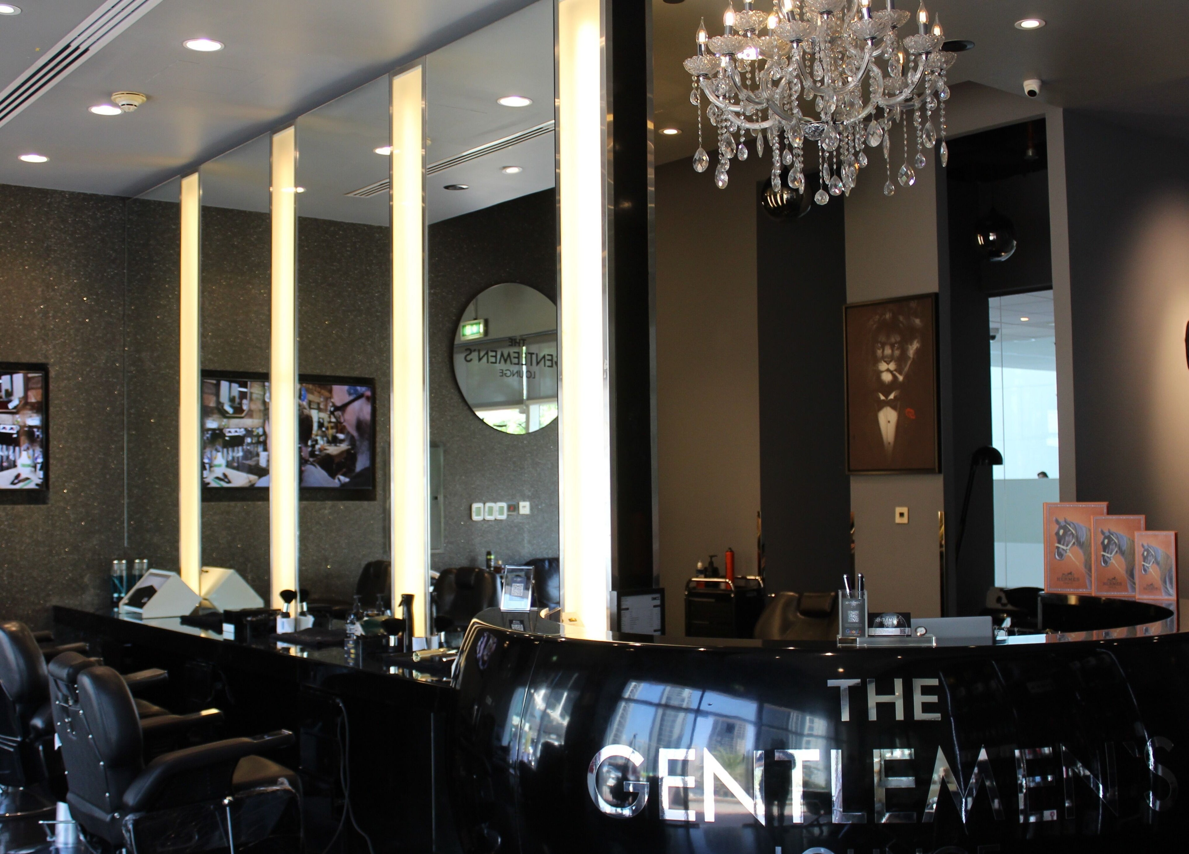 Luxurious interior of The Gentlemen's Lounge in Dubai, AE, showcasing elegant decor and barber chairs.