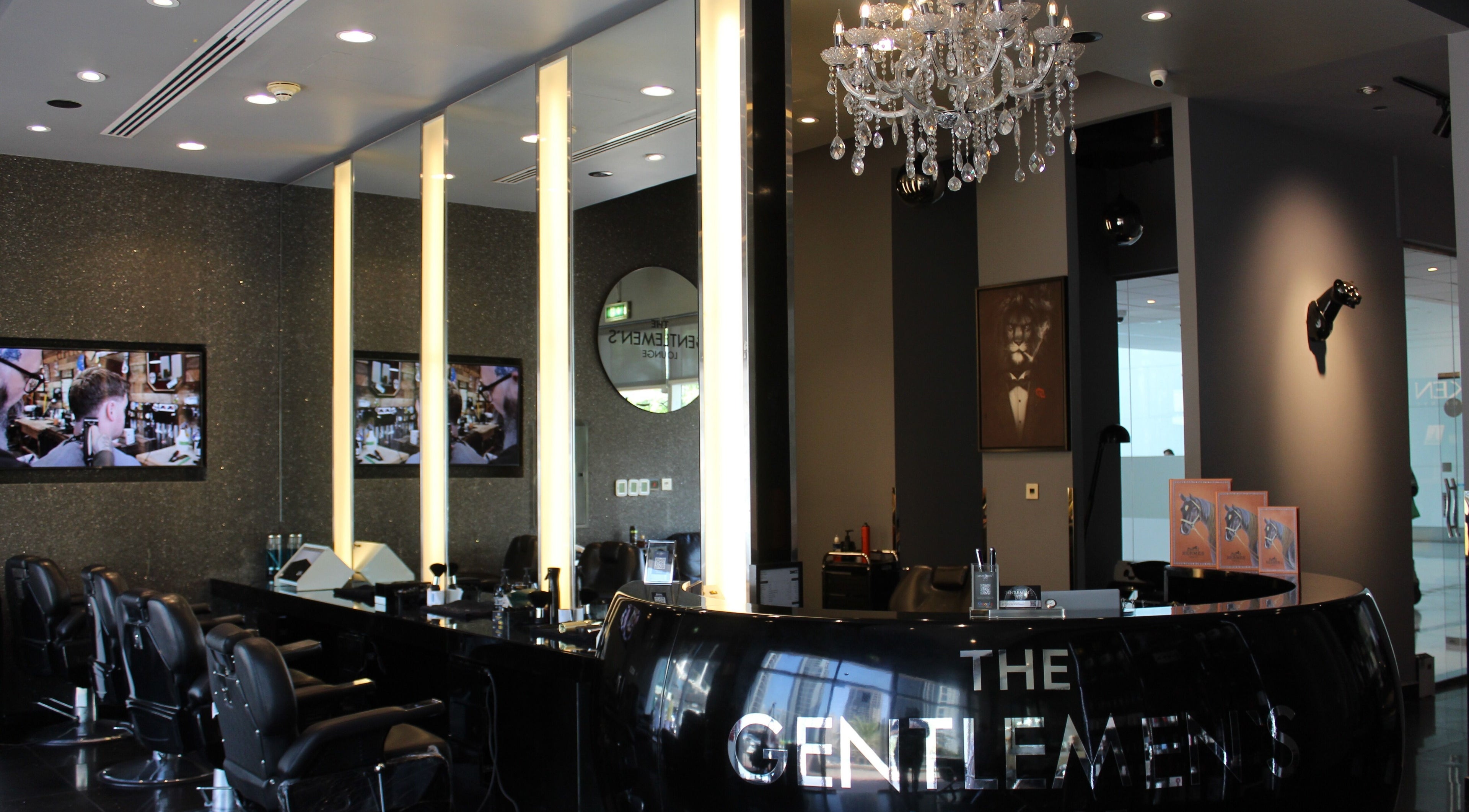 Luxurious interior of The Gentlemen's Lounge in Dubai, AE, showcasing elegant decor and barber chairs.