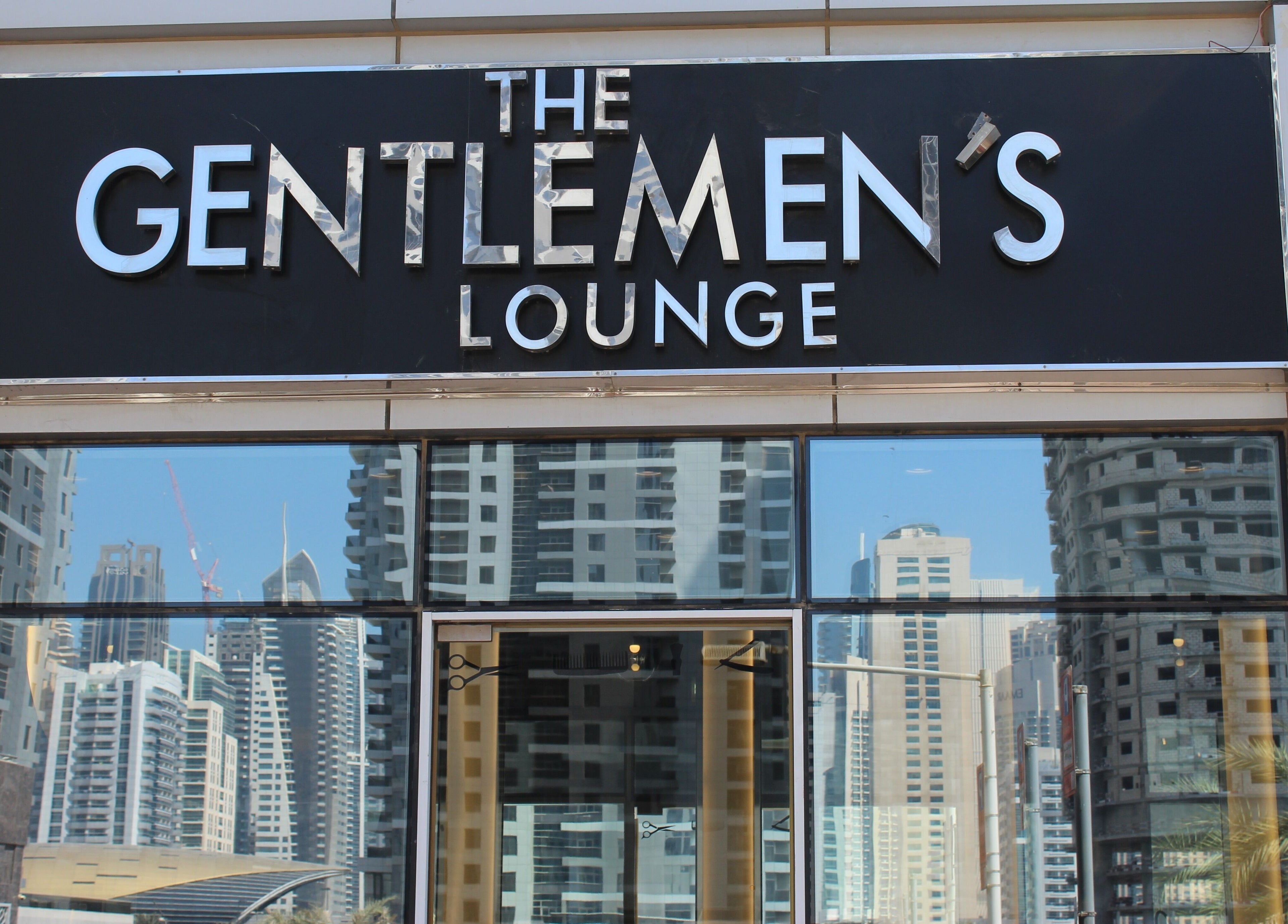 Exterior of The Gentlemen's Lounge in Dubai, Dubai, AE showcasing modern cityscape reflections.