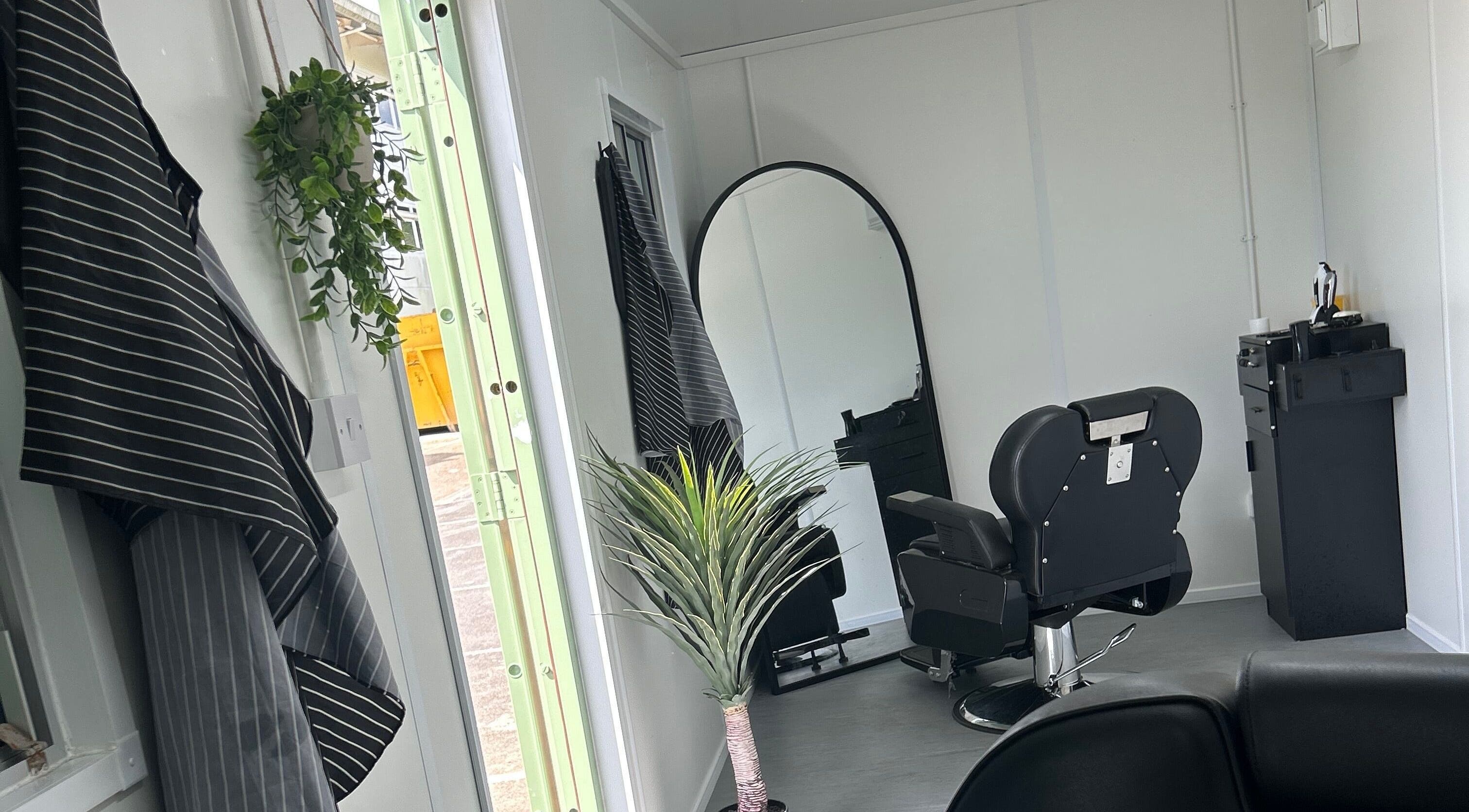 Modern salon interior at Container Cuts - Wilcox House, Cardiff, Wales, GB with sleek decor and a barber chair.