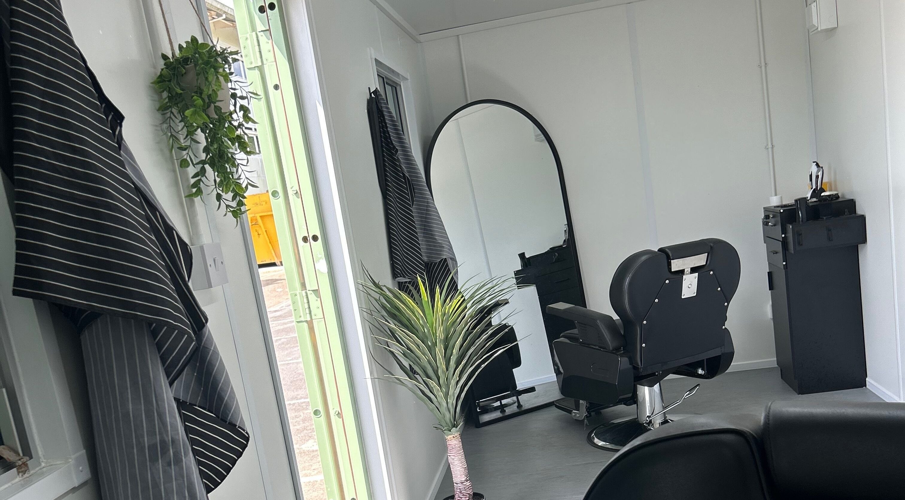 Modern salon interior at Container Cuts - Wilcox House, Cardiff, Wales, GB with sleek decor and a barber chair.