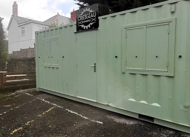 Container Cuts - Wilcox House, Cardiff, Wales, GB: Unique green container salon exterior view.