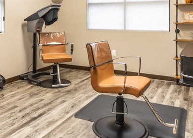 Sleek salon chairs at Its Personal the Salon, Pearland, Texas, US on elegant wood flooring.