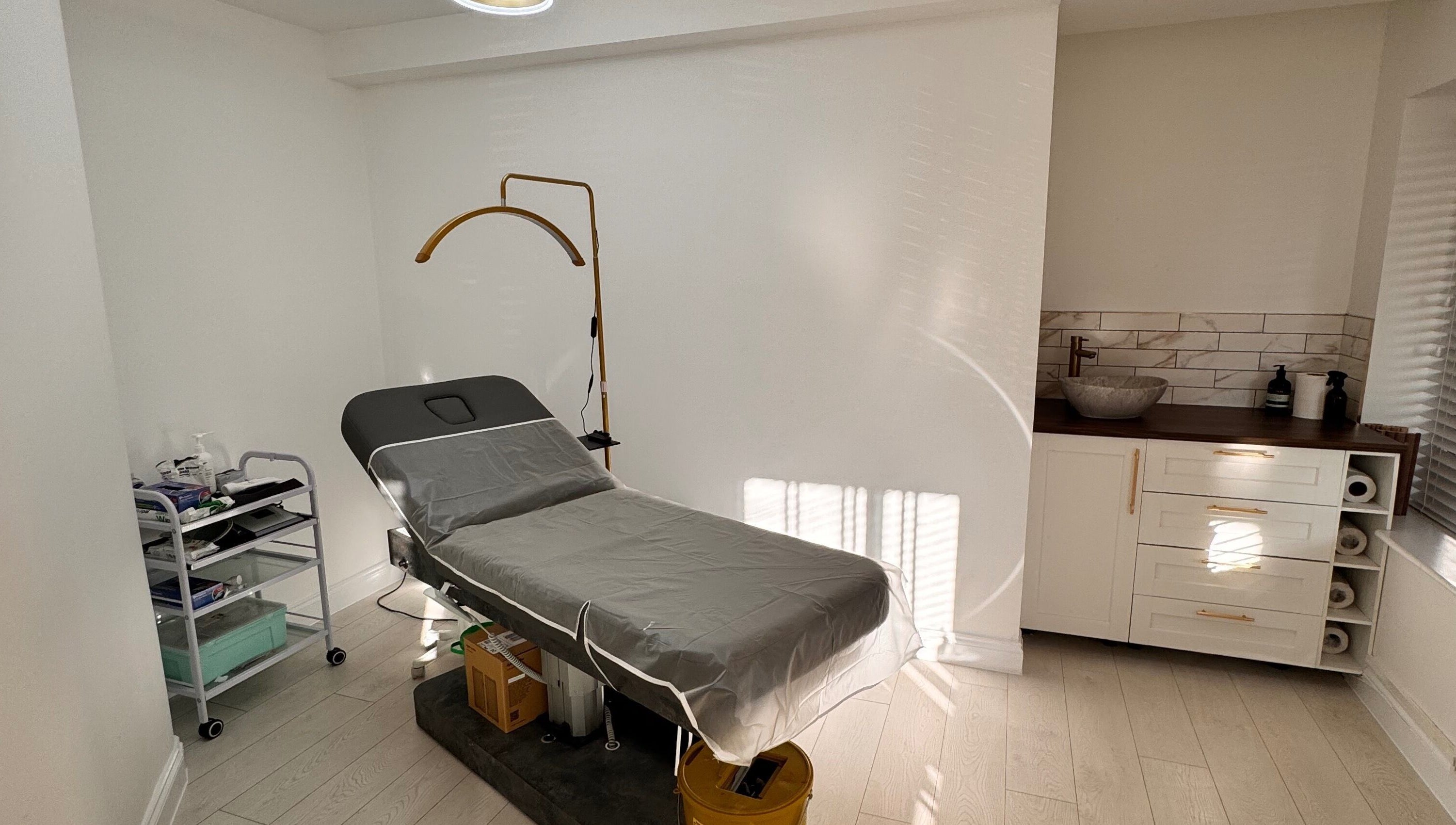 Modern treatment room at Ely Spmu & Aesthetic Clinic in Ely, England, GB, featuring a sleek bed and equipment.