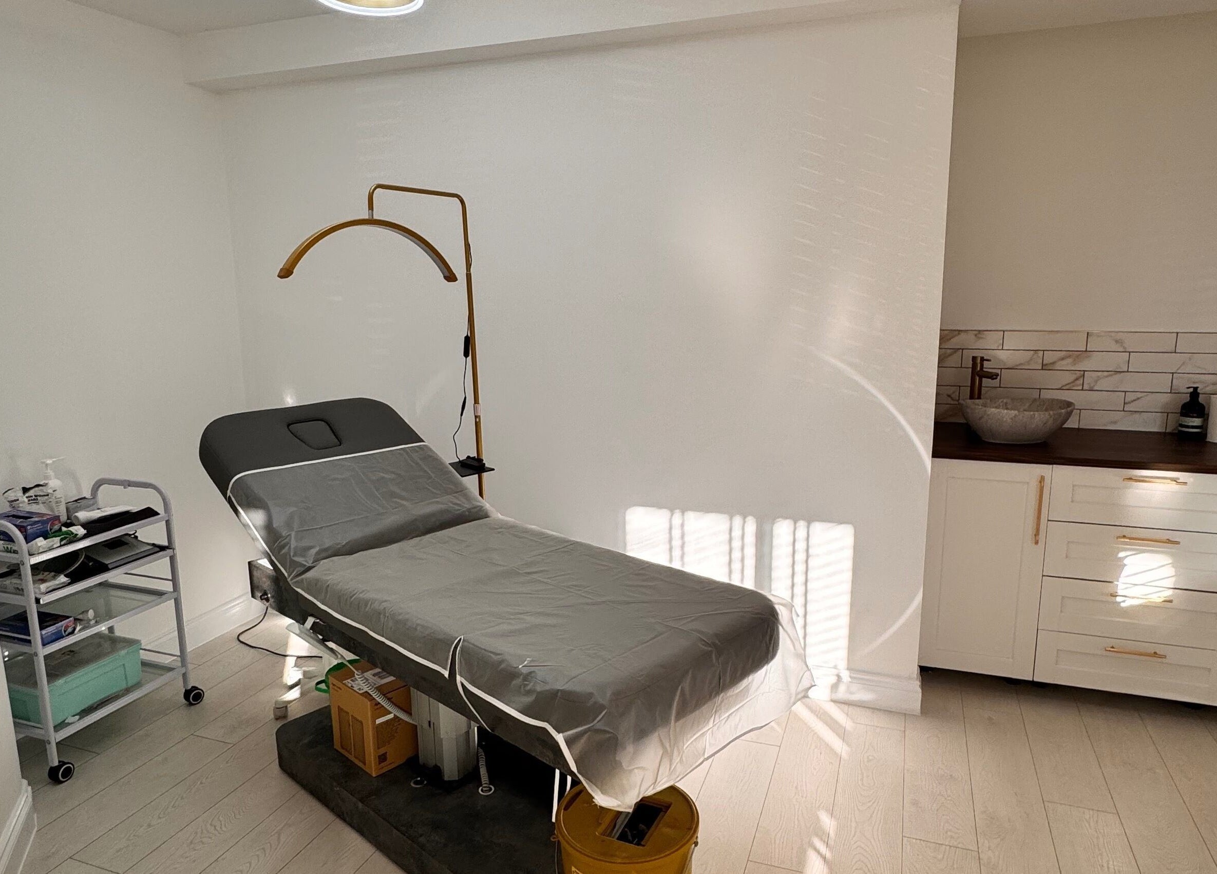 Modern treatment room at Ely Spmu & Aesthetic Clinic in Ely, England, GB, featuring a sleek bed and equipment.