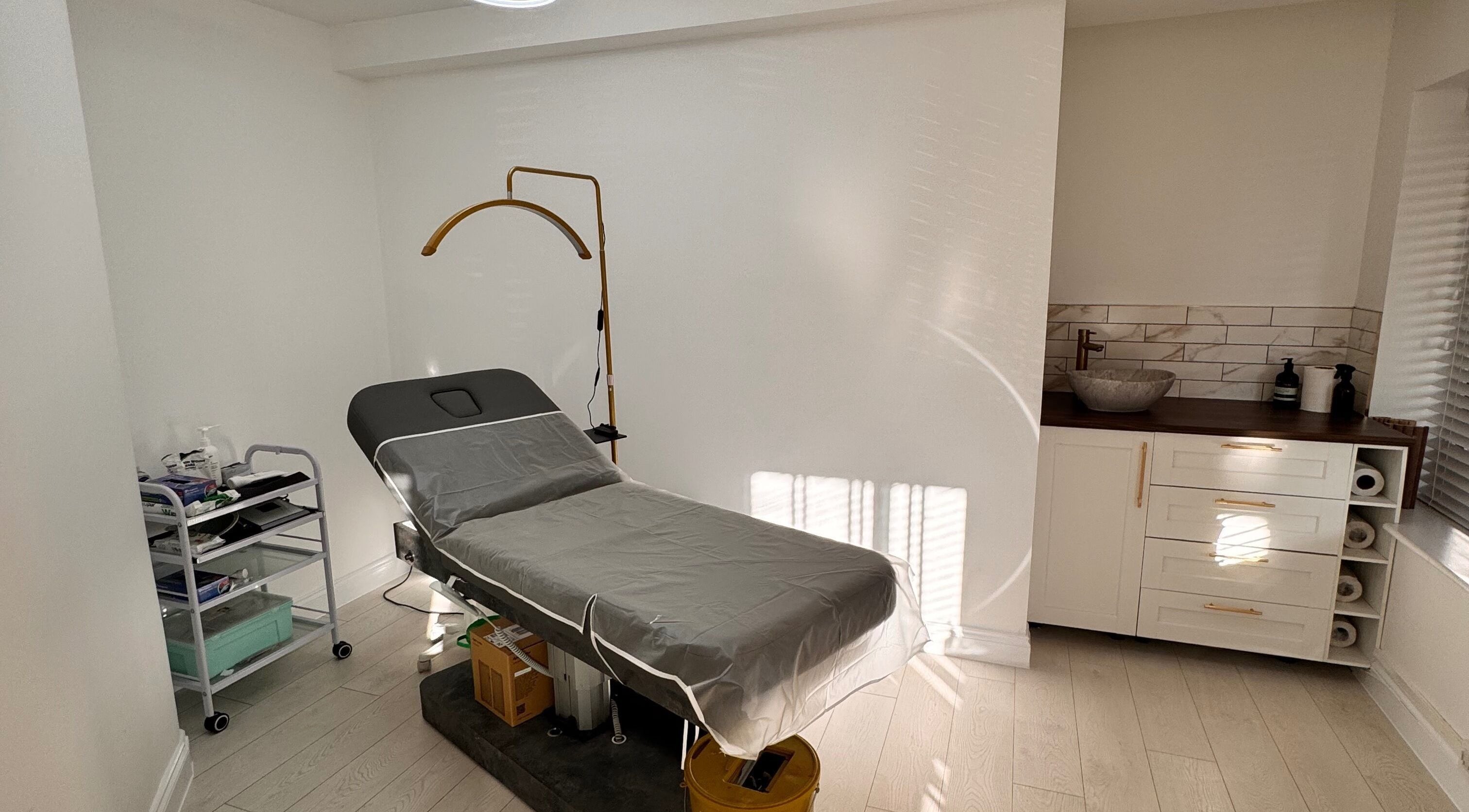 Modern treatment room at Ely Spmu & Aesthetic Clinic in Ely, England, GB, featuring a sleek bed and equipment.