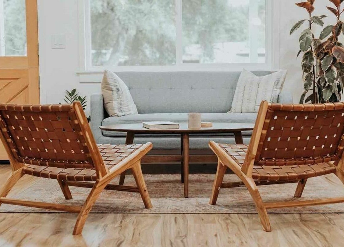 Inviting lounge area at Boheme, Ojai, California, US with modern wooden chairs and a soft gray sofa.