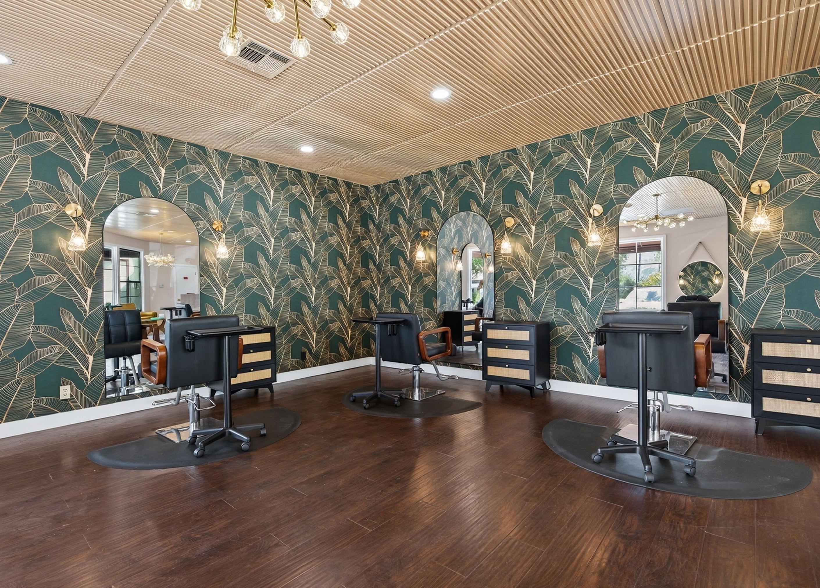 Chic salon interior at Bijou, Ojai, California, US, featuring botanical wallpaper and modern beauty stations.