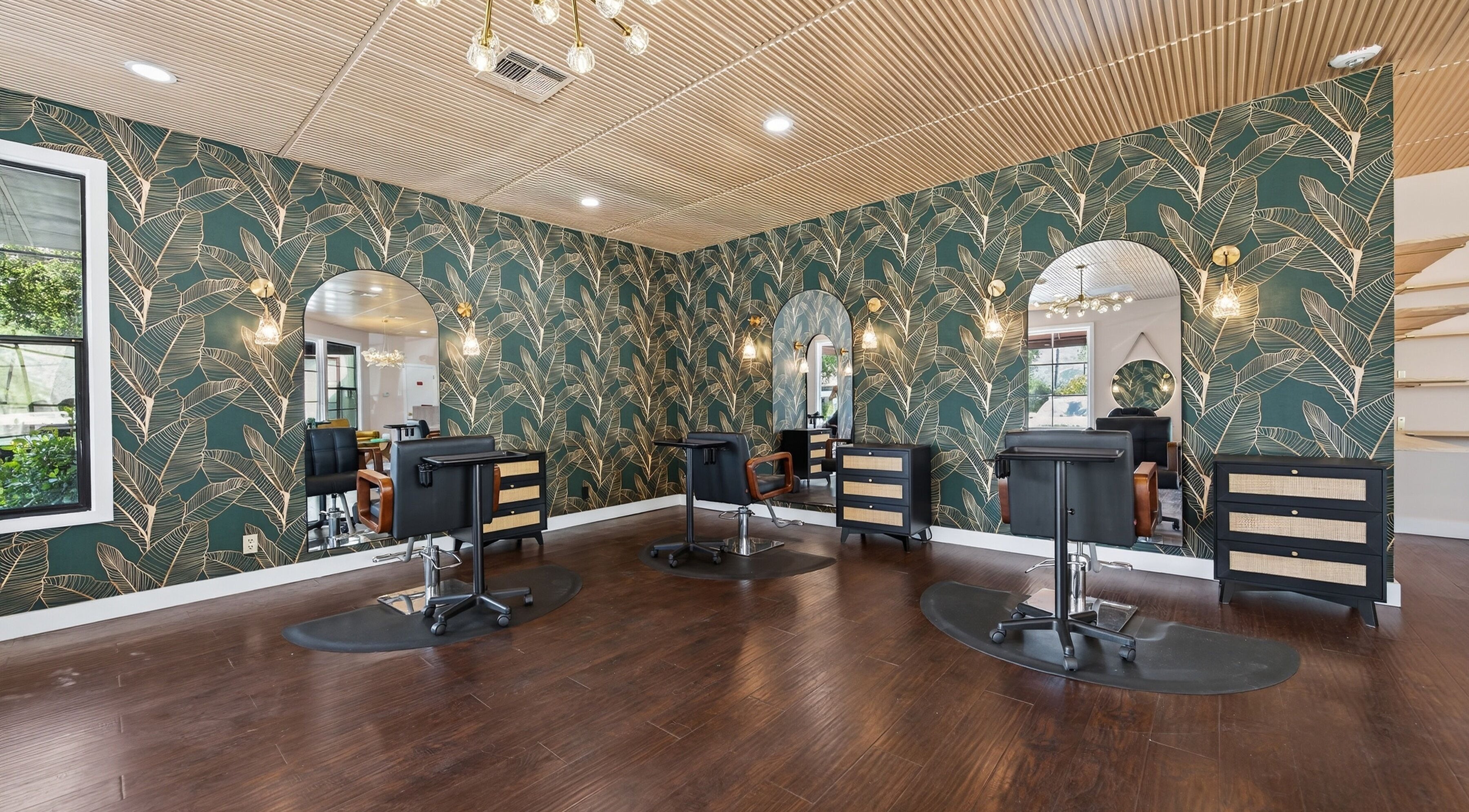 Chic salon interior at Bijou, Ojai, California, US, featuring botanical wallpaper and modern beauty stations.