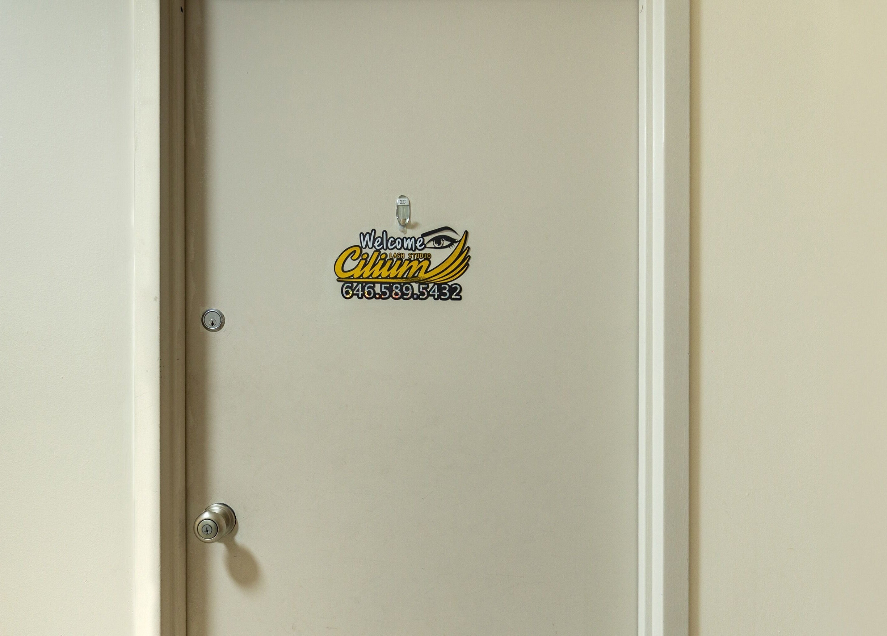 Entrance door of Cilium Lash Studio in New York, New York, US, with studio welcome sign.