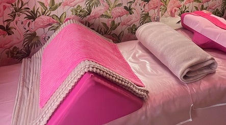 Relaxing pink treatment bed at Lashes by Leesh Bledington, Chipping Norton, England, GB with flamingo wallpaper.