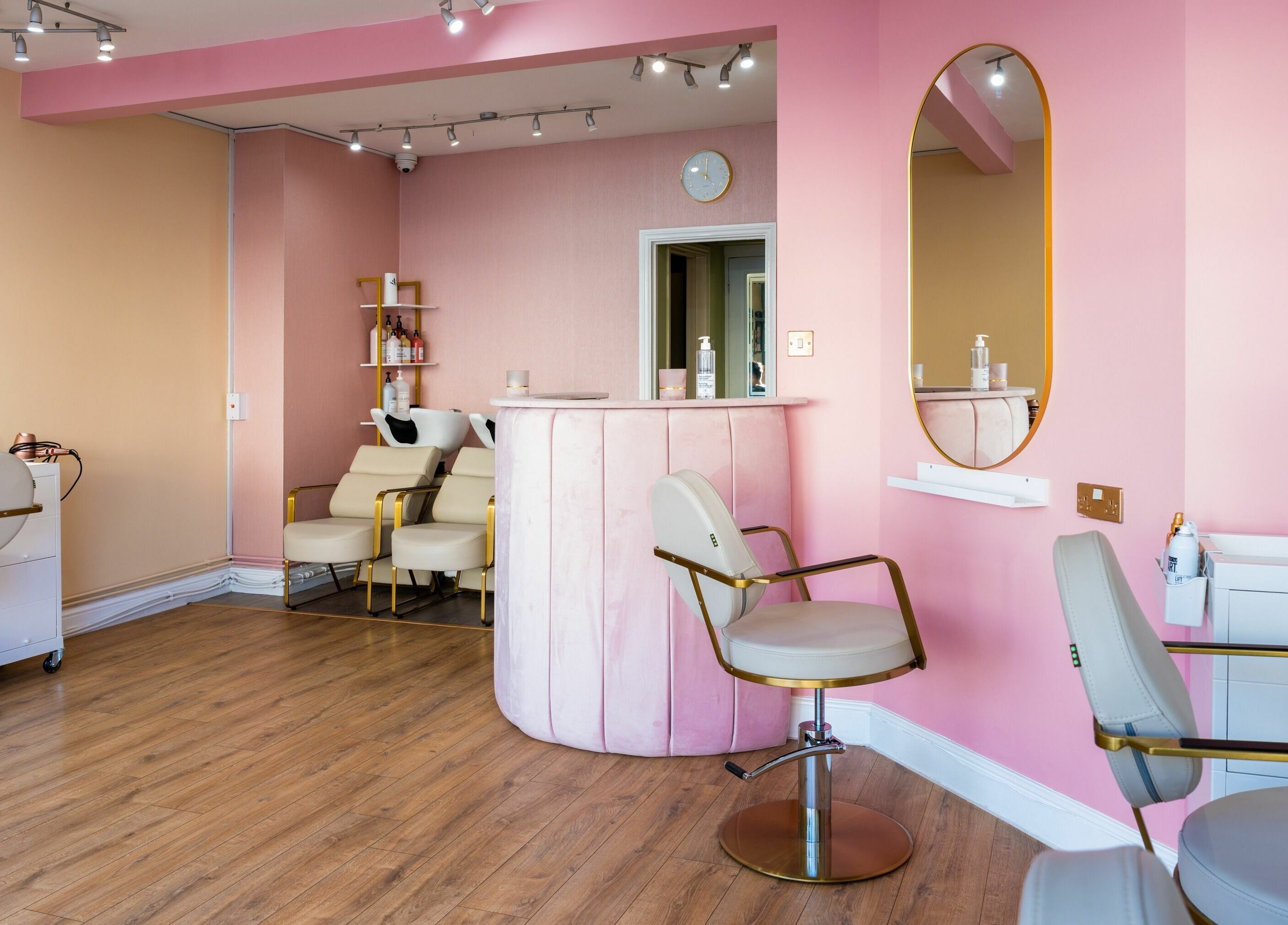Stylish salon interior at Head Start, Swanscombe, England, GB, featuring elegant chairs and pink decor.