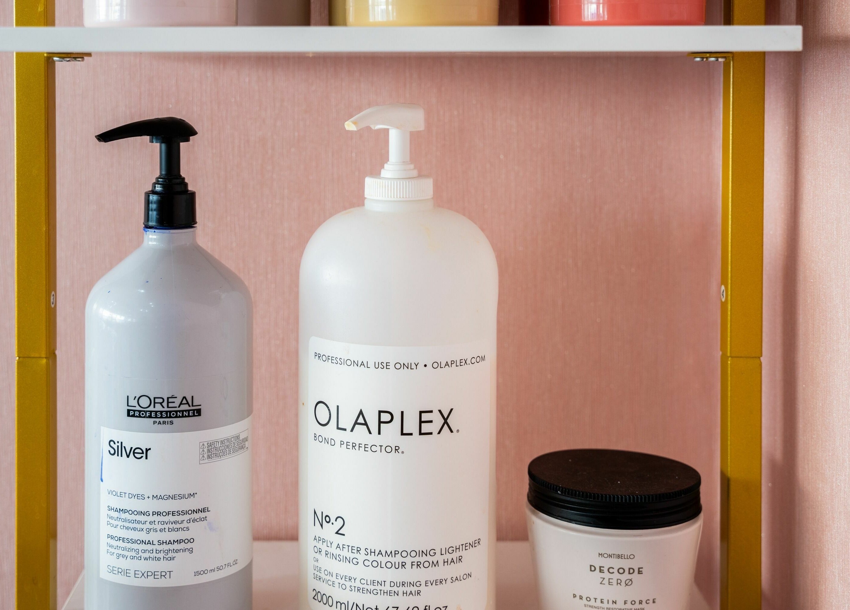 Hair product display at Head Start, Swanscombe, England, GB showcasing Olaplex and L'Oreal bottles.