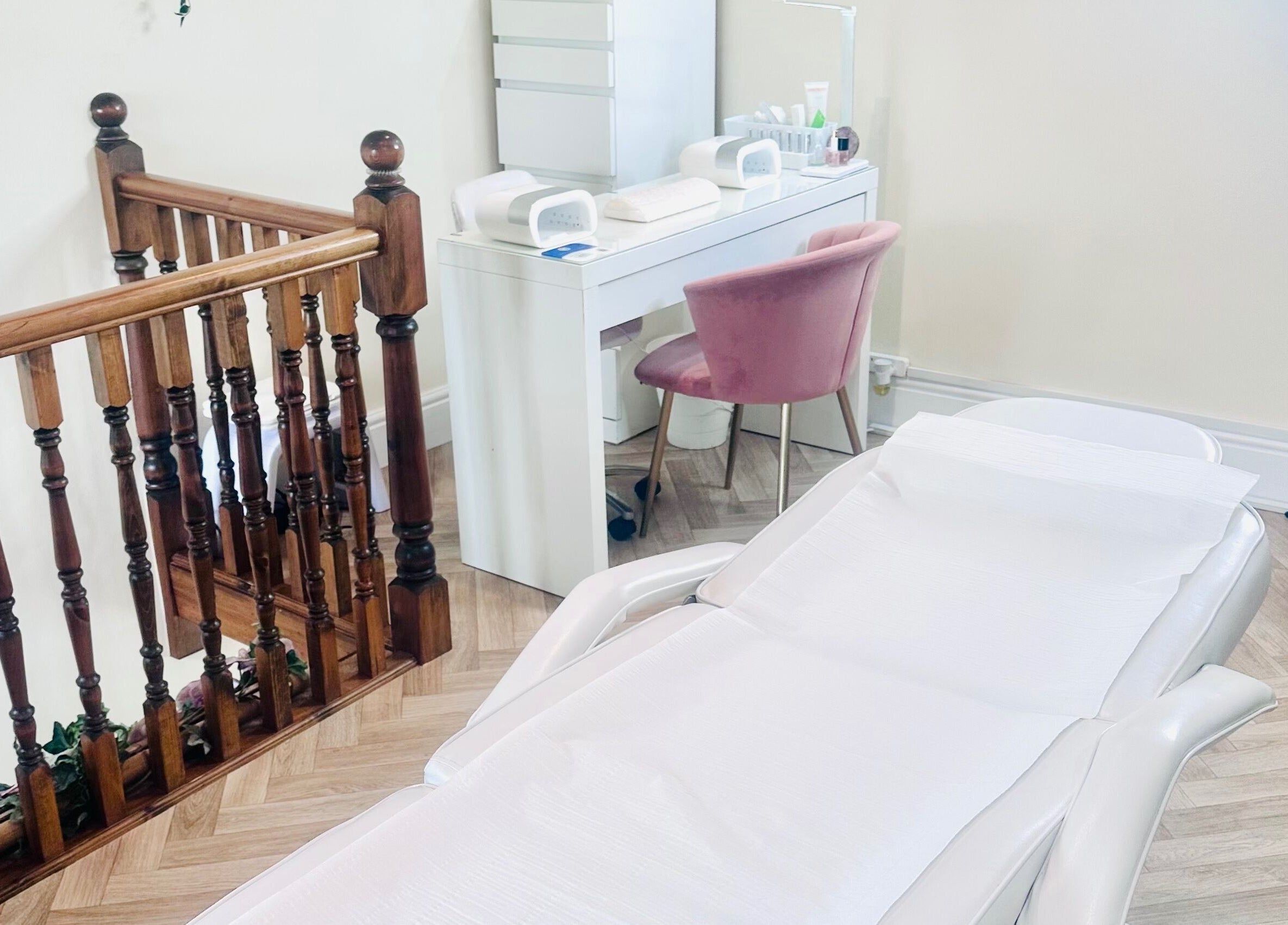 Treatment room at La Bonne Vie in Cawood, England, GB with a pink chair and a white treatment bed.
