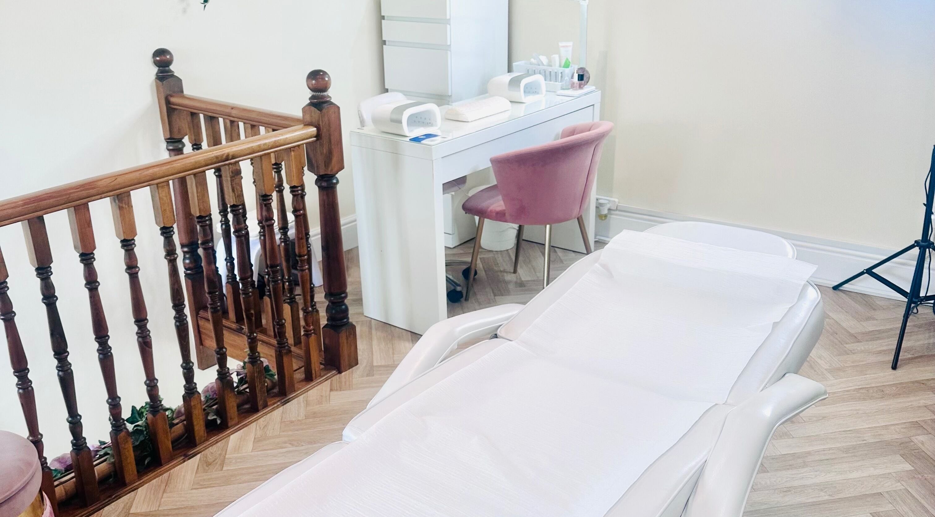 Treatment room at La Bonne Vie in Cawood, England, GB with a pink chair and a white treatment bed.