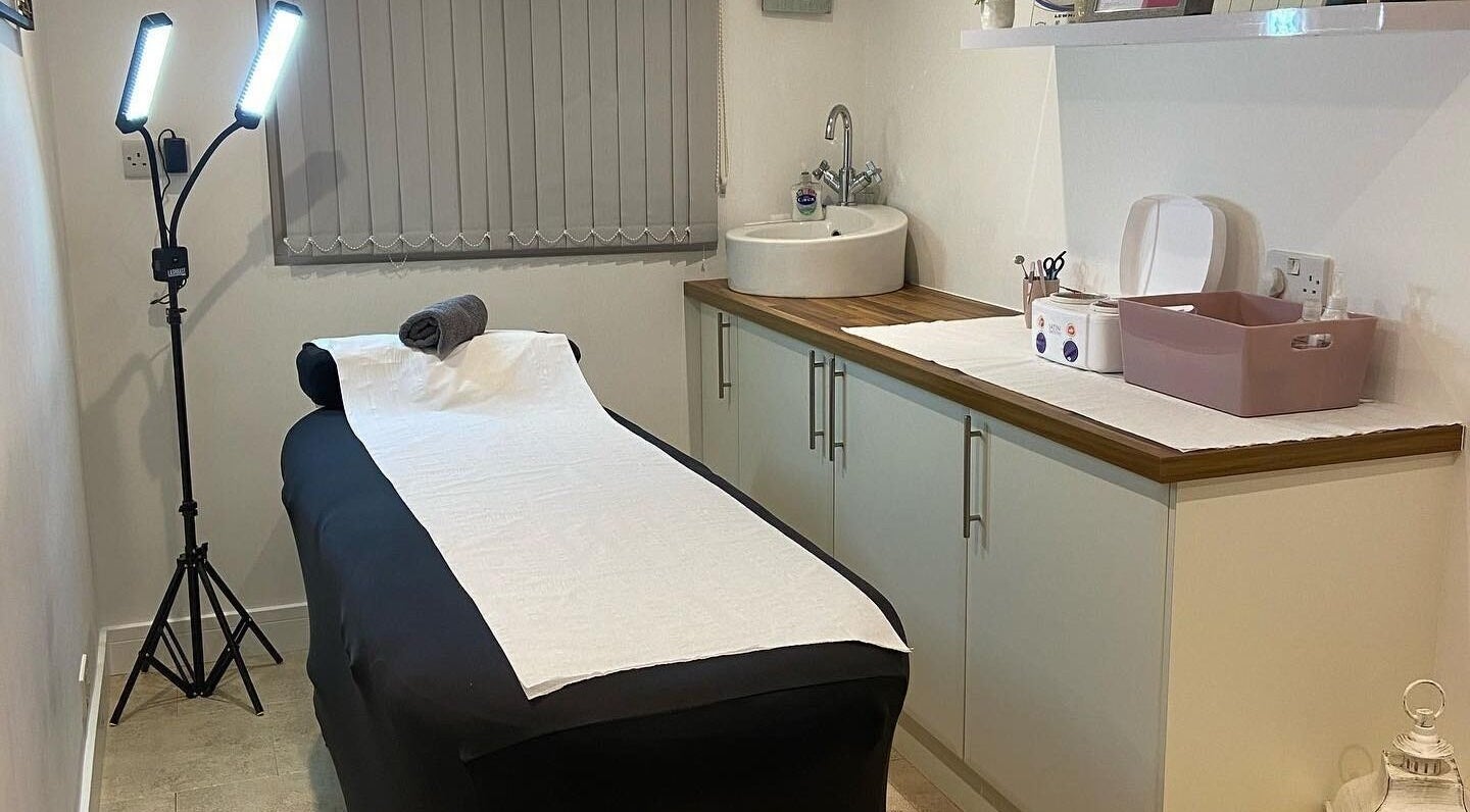 Cozy treatment room at Debeaut by Della in Havant, England, GB, featuring a massage table and calming decor.