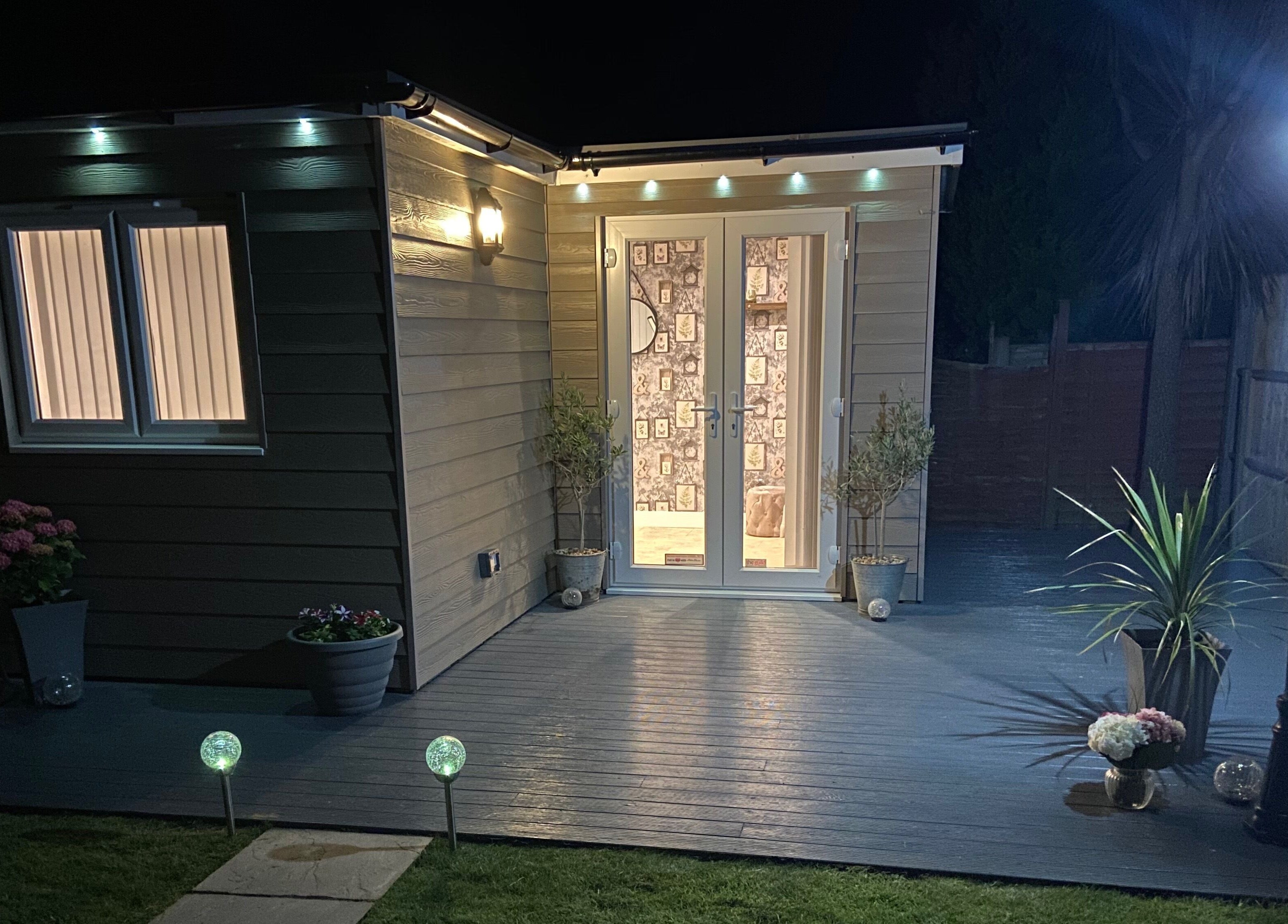 Night view of Debeaut by Della entrance in Havant, England, GB, with soft lighting and plants.