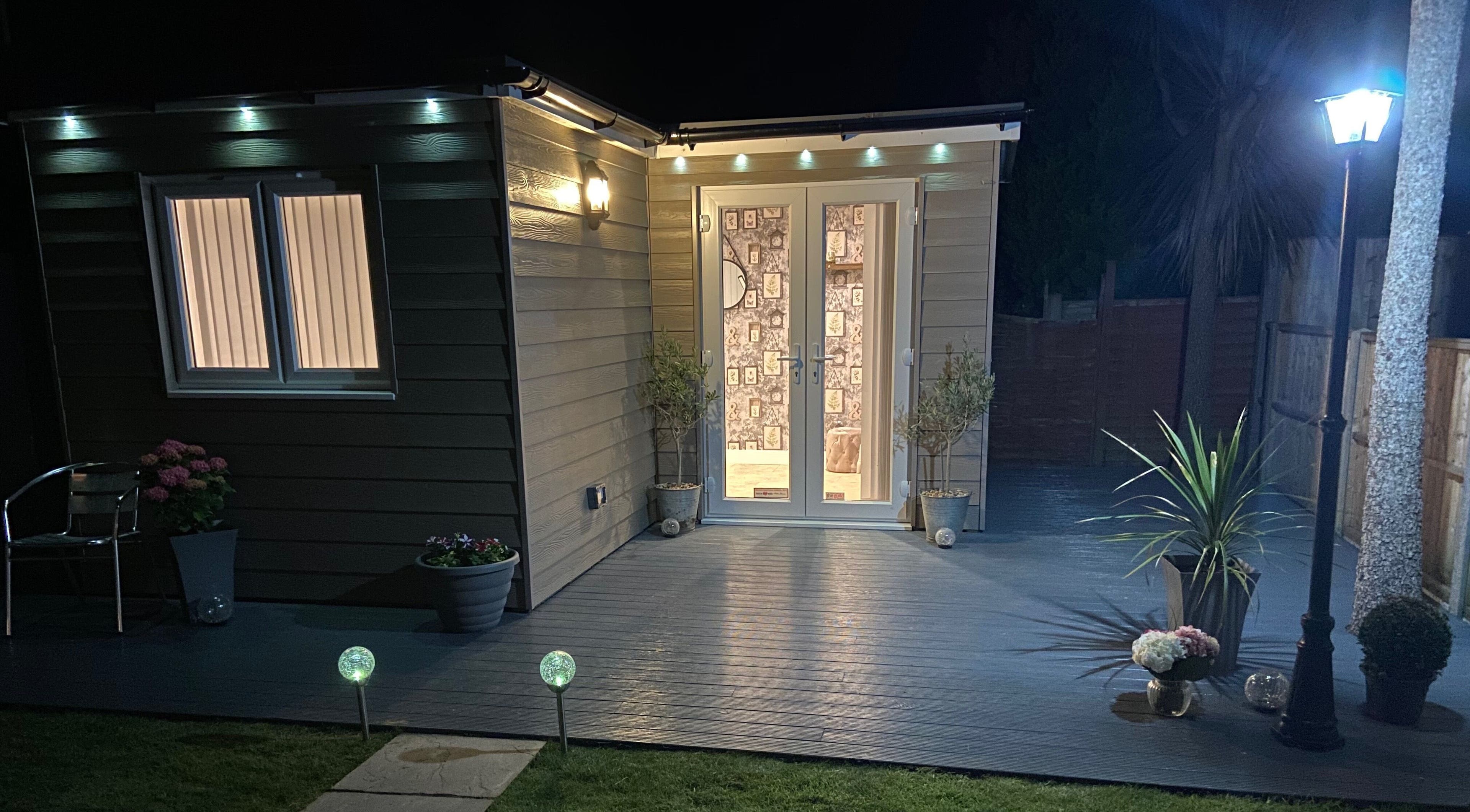 Night view of Debeaut by Della entrance in Havant, England, GB, with soft lighting and plants.