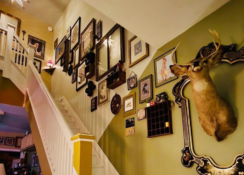 Stairway with eclectic decor at Obscura - Art, Tattoo + Body Mod. Studio, Long Beach, New York, US.
