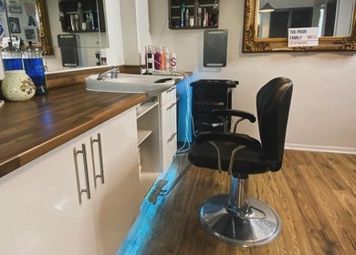 Stylish salon interior at Amy Rawlings Hairdressing in Worthing, England, GB, wooden floor and ornate mirror.