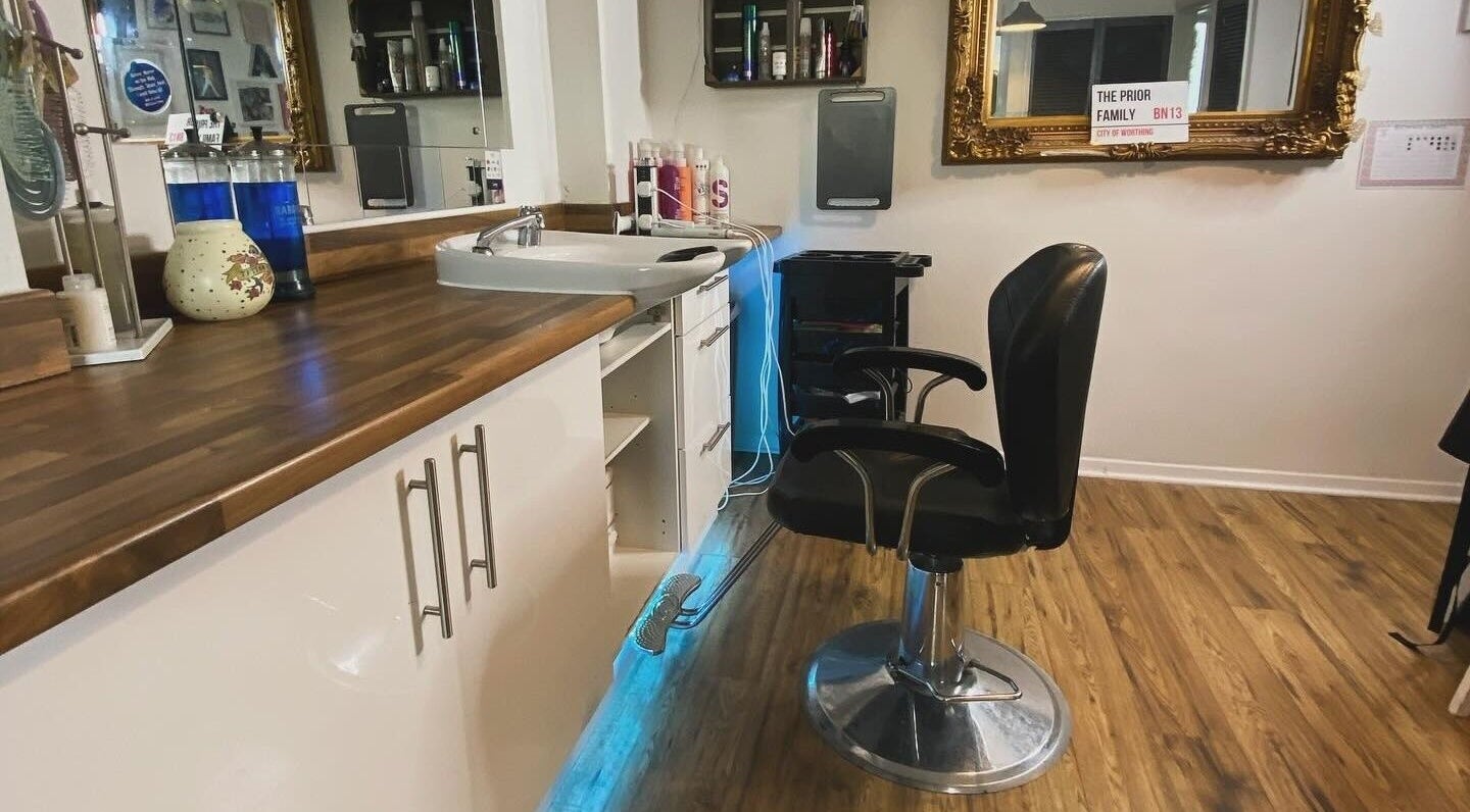 Stylish salon interior at Amy Rawlings Hairdressing in Worthing, England, GB, wooden floor and ornate mirror.