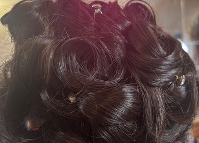 Intricate updo hairstyle at Amy Rawlings Hairdressing in Worthing, England, GB, showcasing glossy brunette curls.