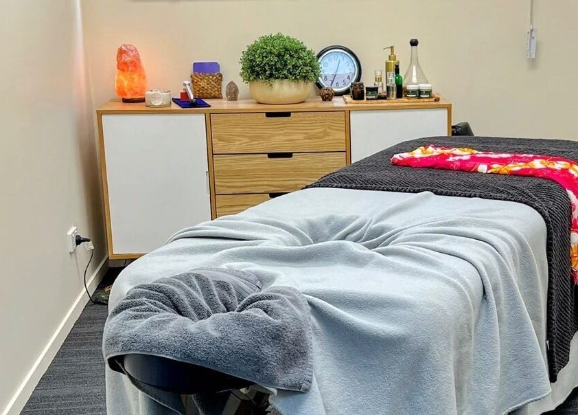 Massage table at Te Whare O Kawakawa Spa, Fairfield, Hamilton, NZ, with calming decor and ambient lighting.