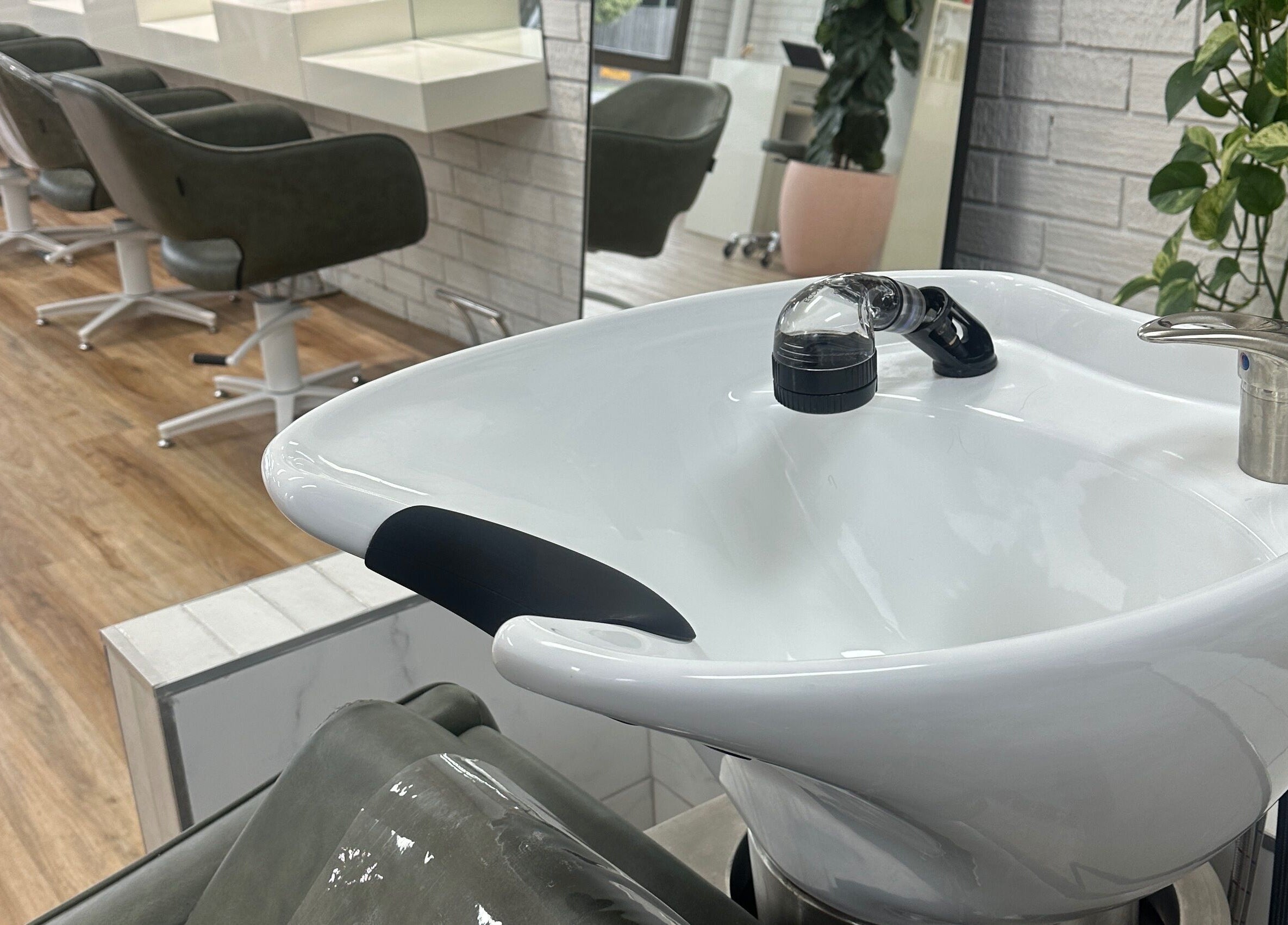 Modern salon interior at Two Blondes, Melbourne, Victoria, AU, featuring chic styling chairs and wash basin.