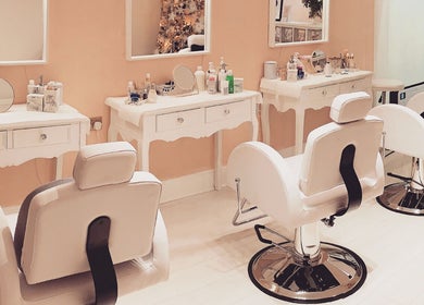 Elegant makeup stations at Breeze Brow and Lash in Glasgow, Scotland, GB, with plush white chairs and mirrors.