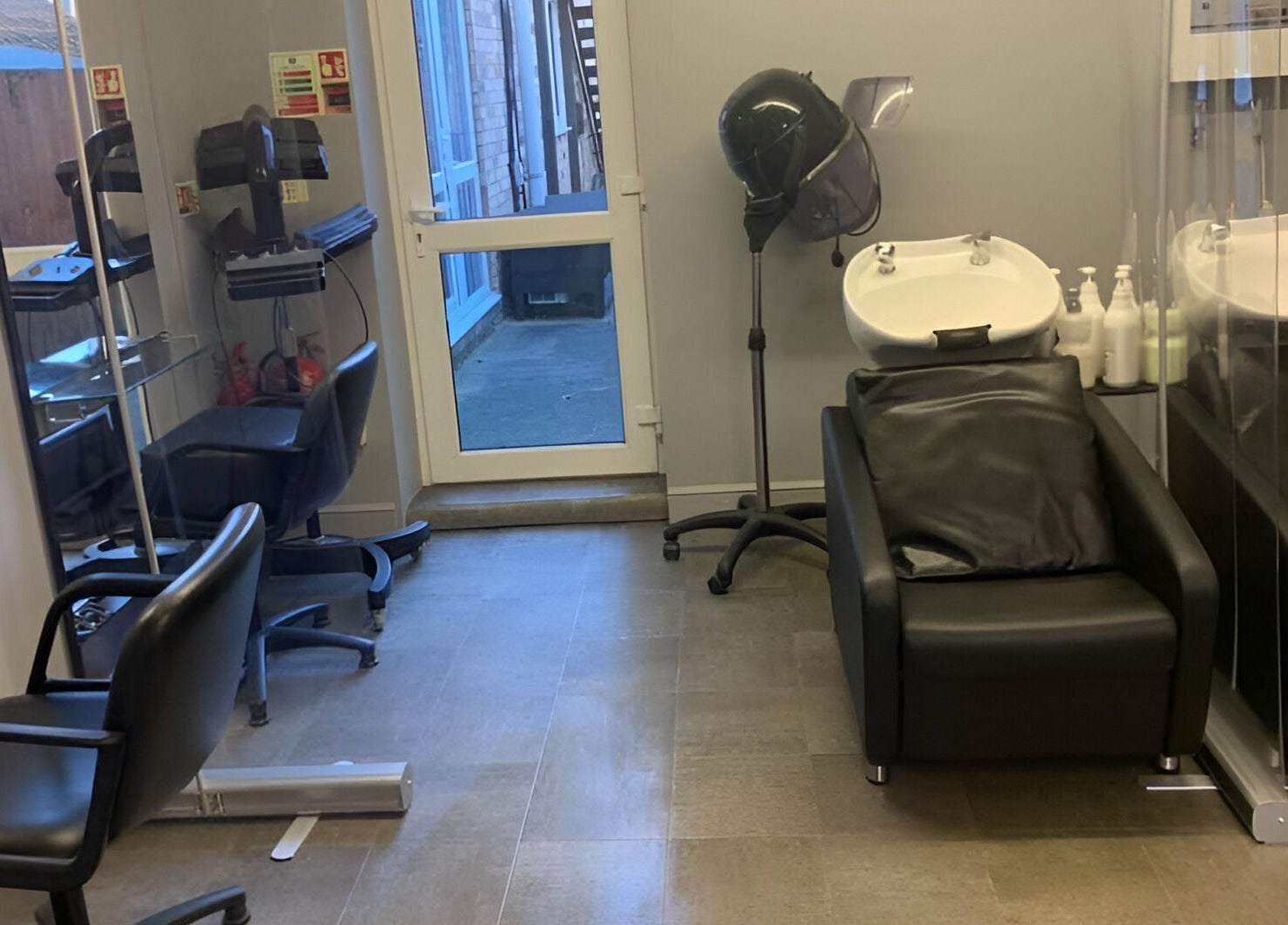 Modern hair salon at Headlines in Ramsey, England, GB featuring sleek black styling chairs and wash basins.